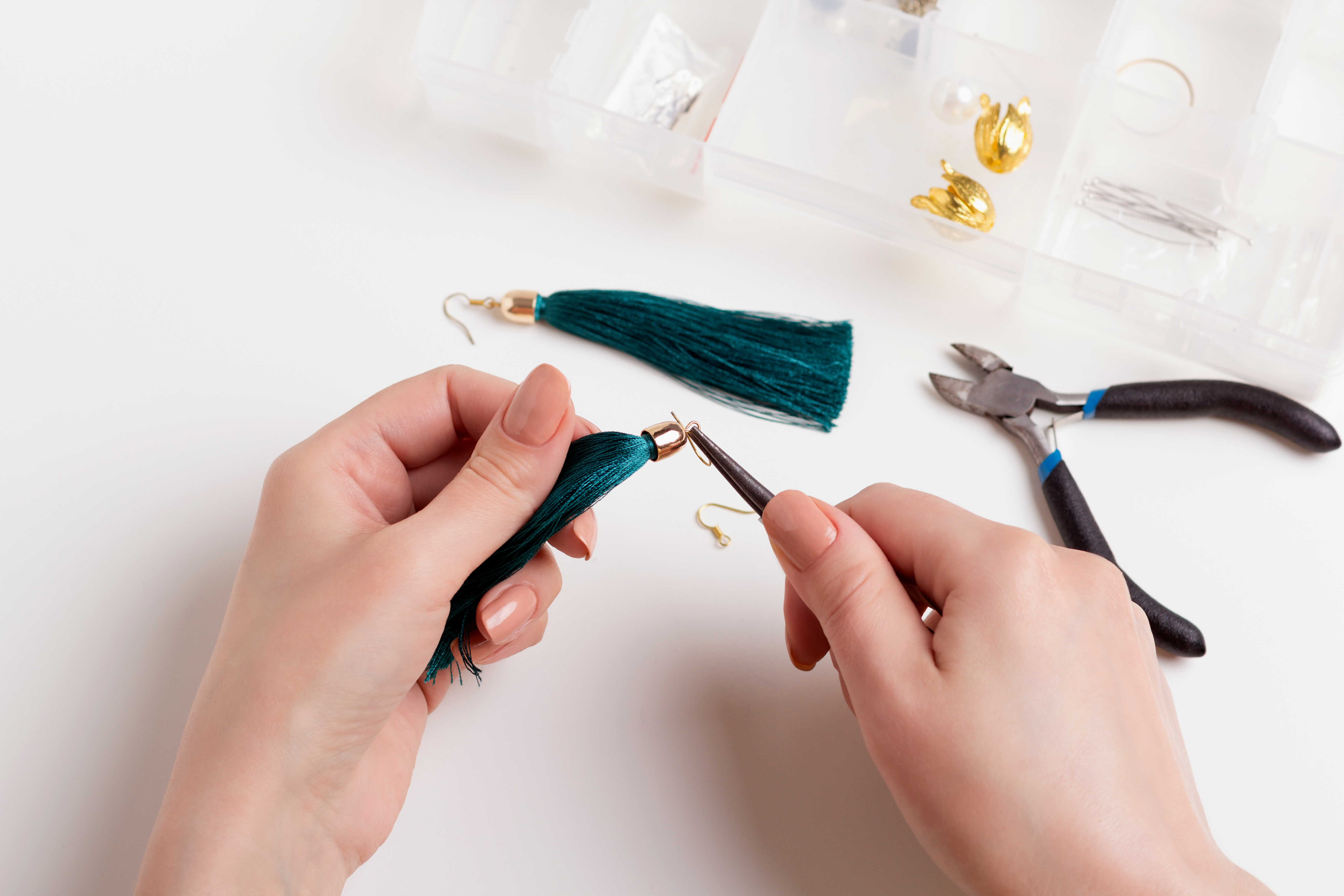 Person using pliers to bend earrings 