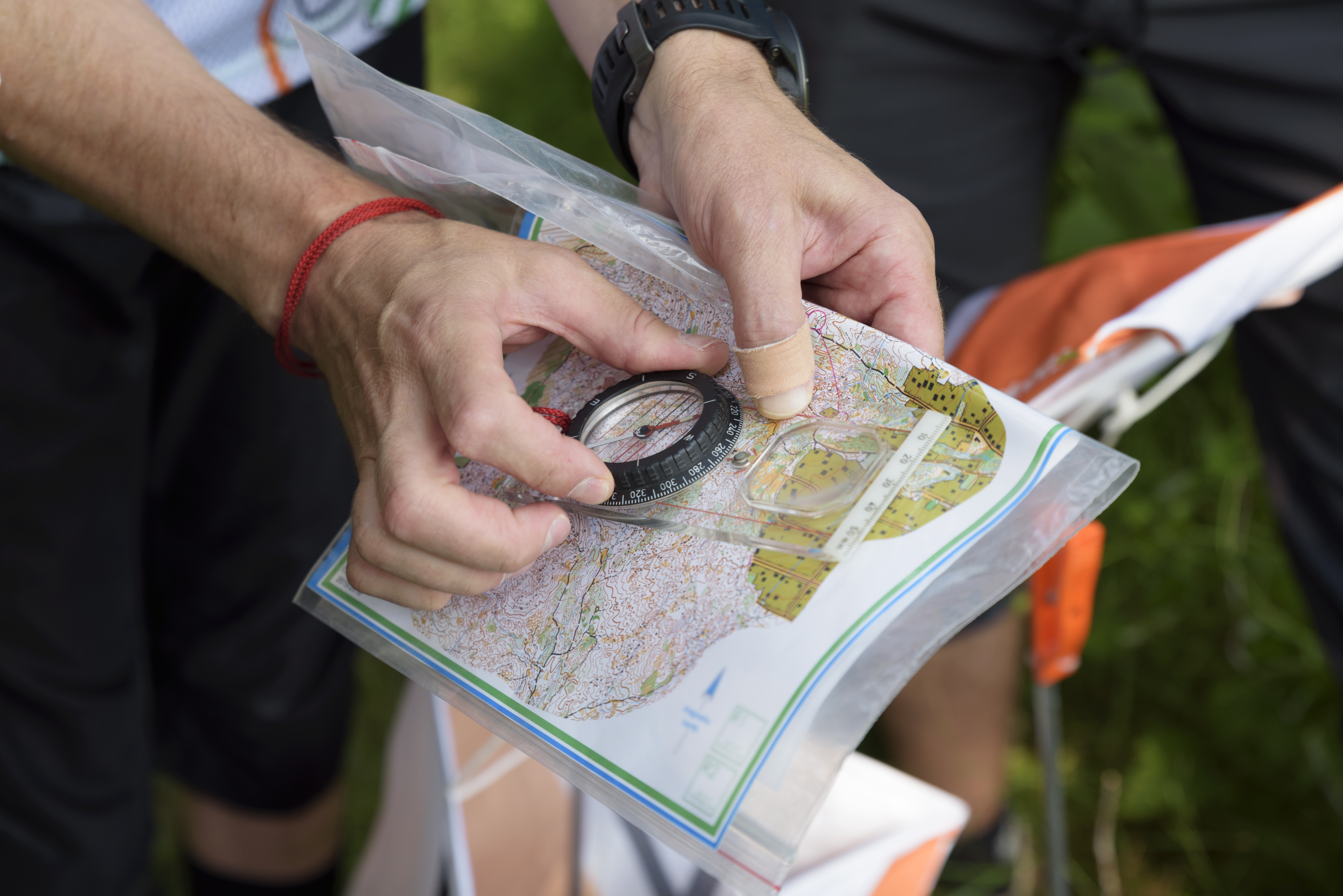A person holds a topographical map and compass.