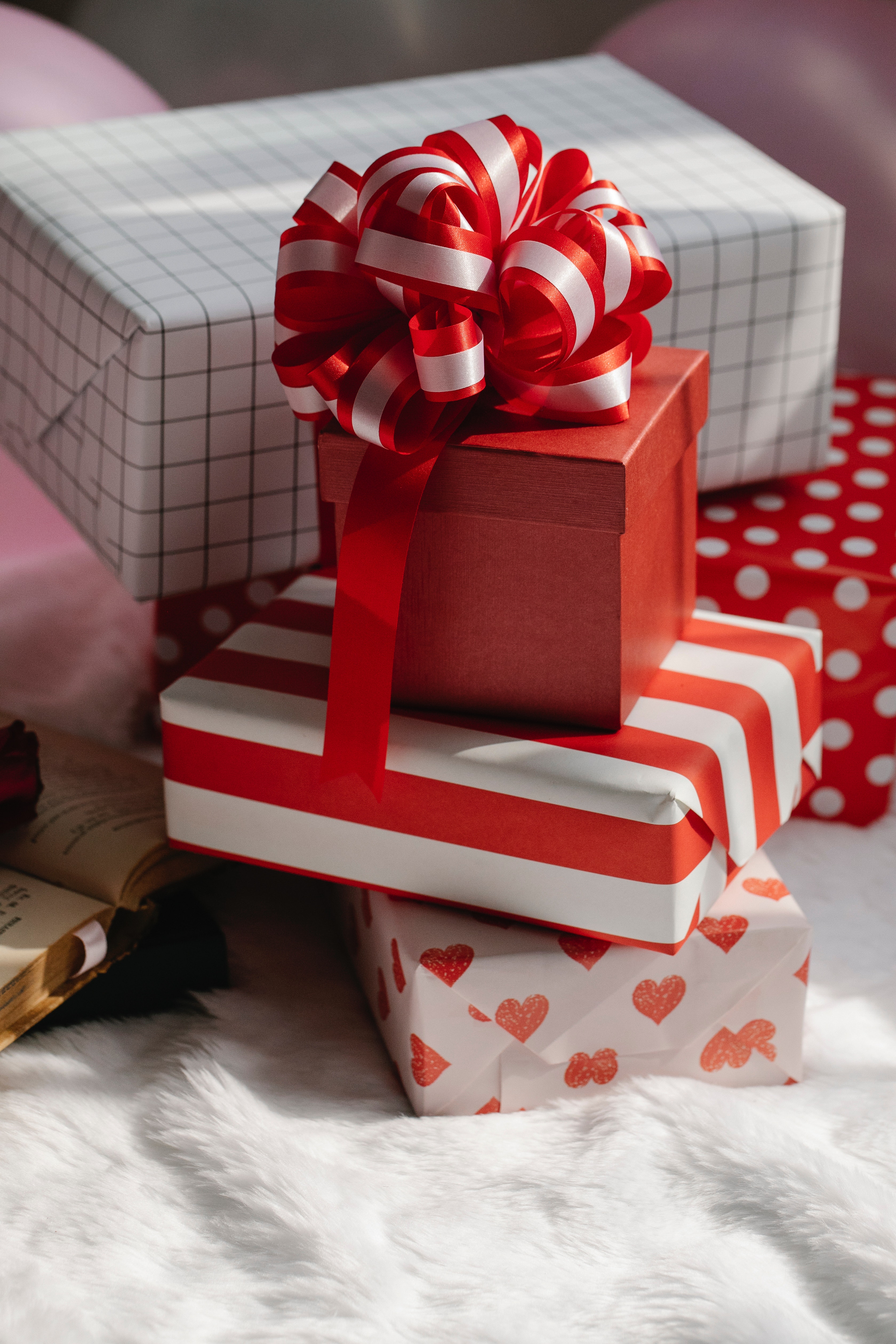A stack of five packages wrapped in white and read wrapping paper