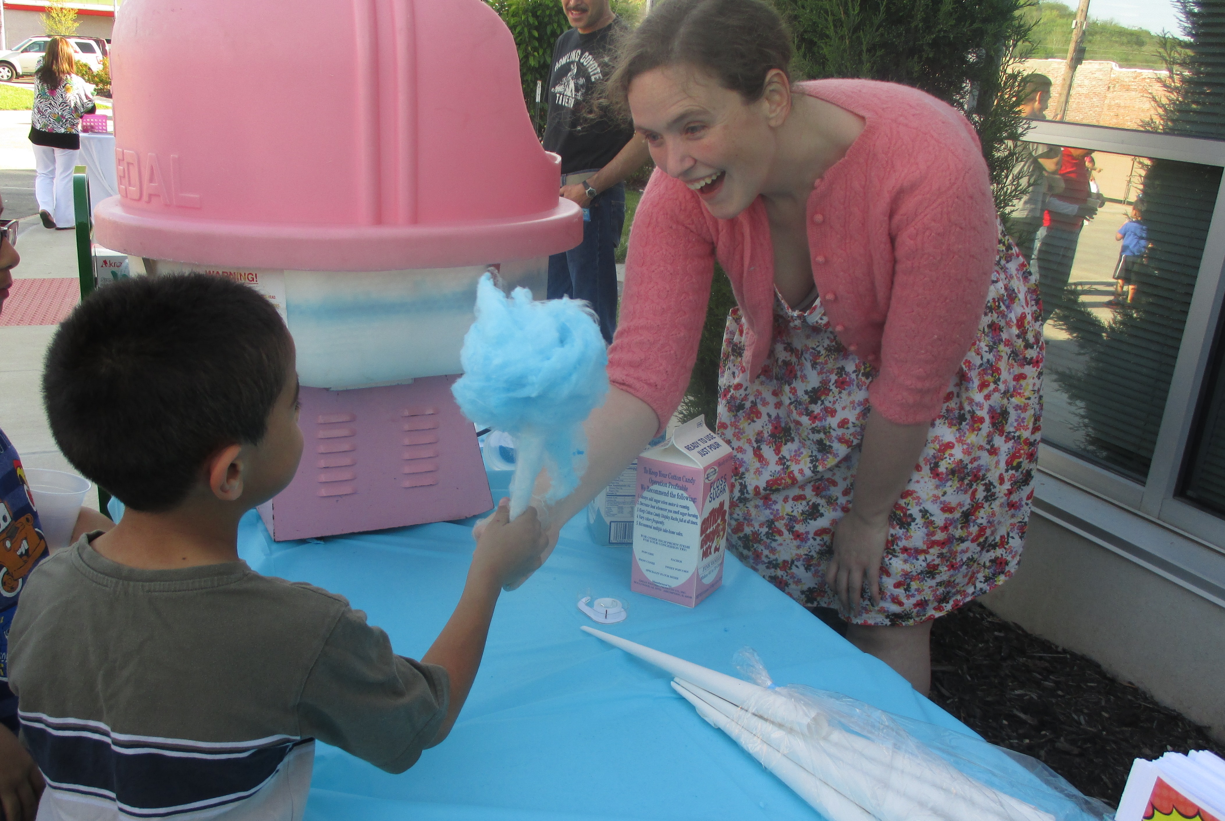 woman handing child cotton candy