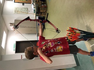 A child is shooting archery. 