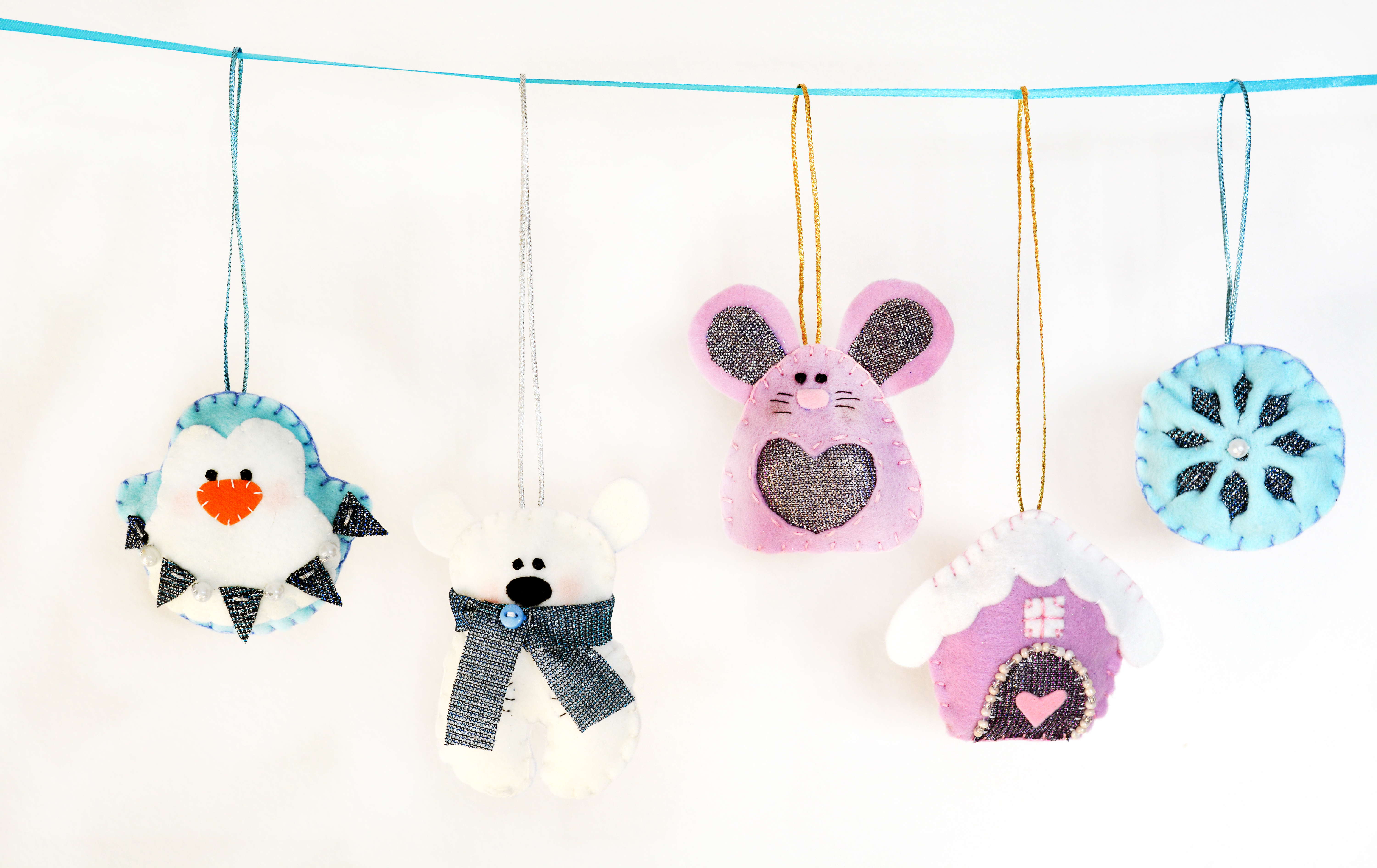 A collection of blue, pink, and white felt hand sewn ornaments.