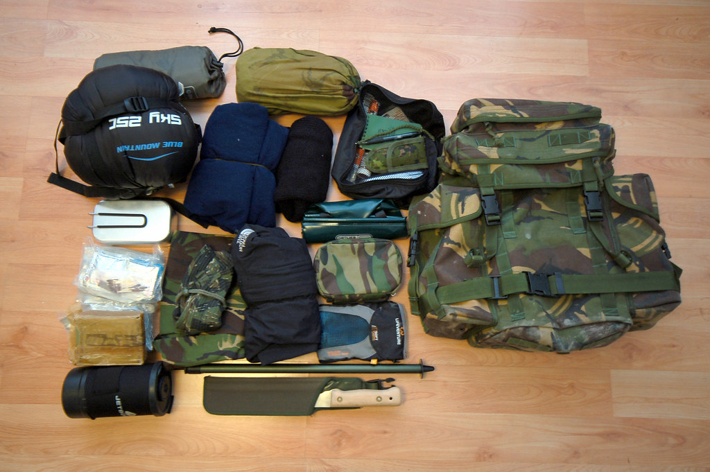 A backpack and its emergency preparedness contents is laid out on the floor. 