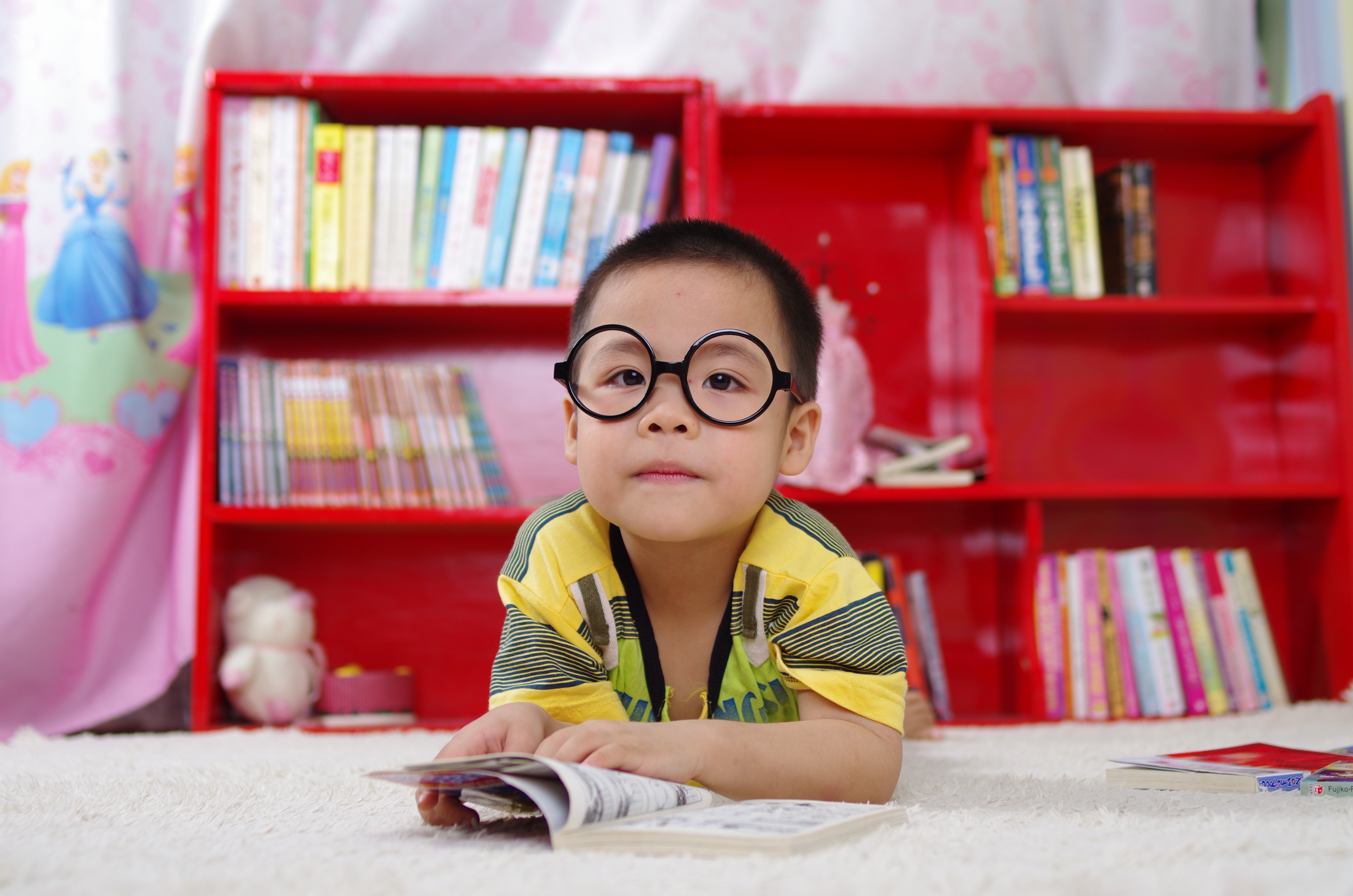 Boy wearing glasses reading book