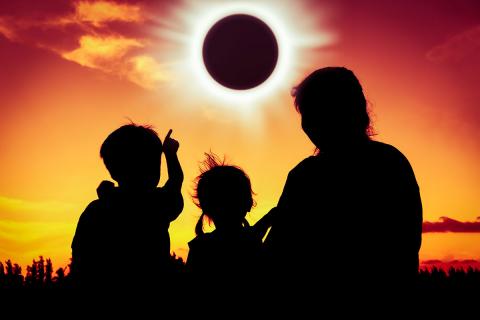 Silhouette family watching eclipse