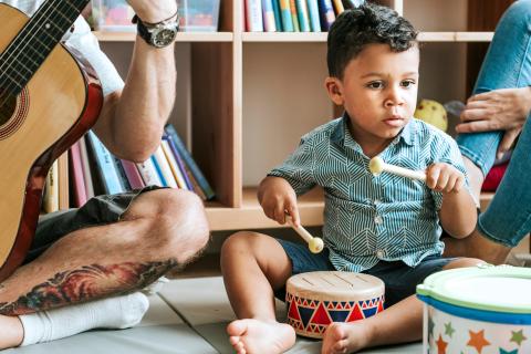 little boy playing small drum