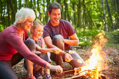 family roasting marshmallows around campfire
